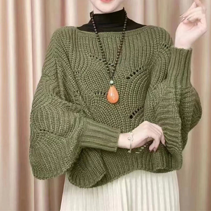 "Elegant långstickad damponcho med fladdermusärmar, ger stil och värme, i mjuk grå ton."