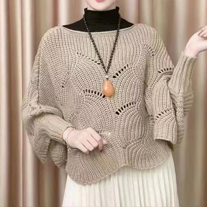 "Elegant långstickad damponcho med fladdermusärmar, ger stil och värme, i mjuk grå ton."