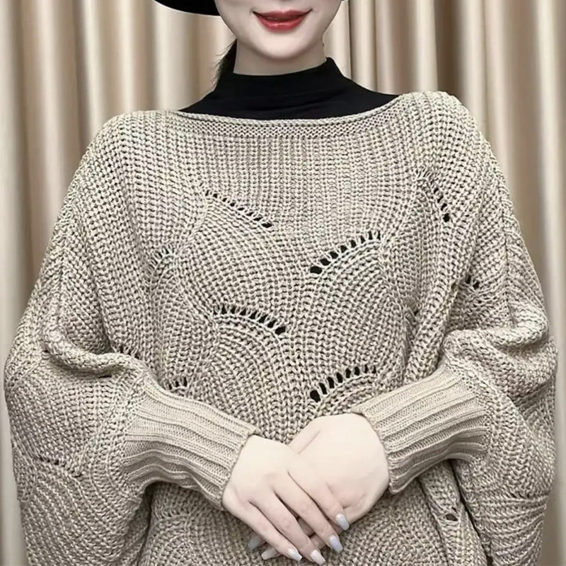 "Elegant långstickad damponcho med fladdermusärmar, ger stil och värme, i mjuk grå ton."