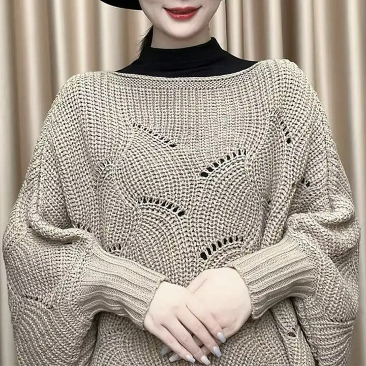 "Elegant långstickad damponcho med fladdermusärmar, ger stil och värme, i mjuk grå ton."