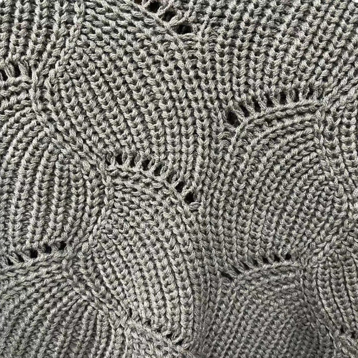 "Elegant långstickad damponcho med fladdermusärmar, ger stil och värme, i mjuk grå ton."