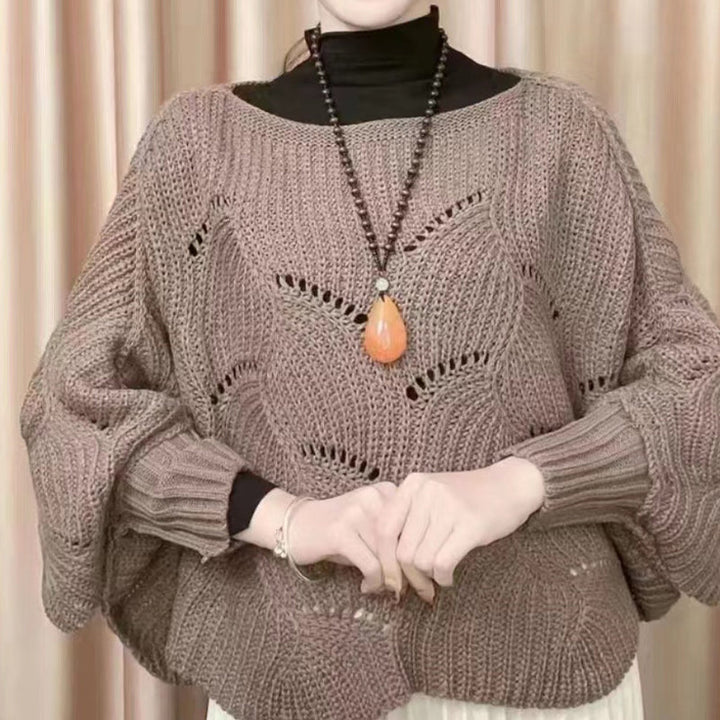 "Elegant långstickad damponcho med fladdermusärmar, ger stil och värme, i mjuk grå ton."