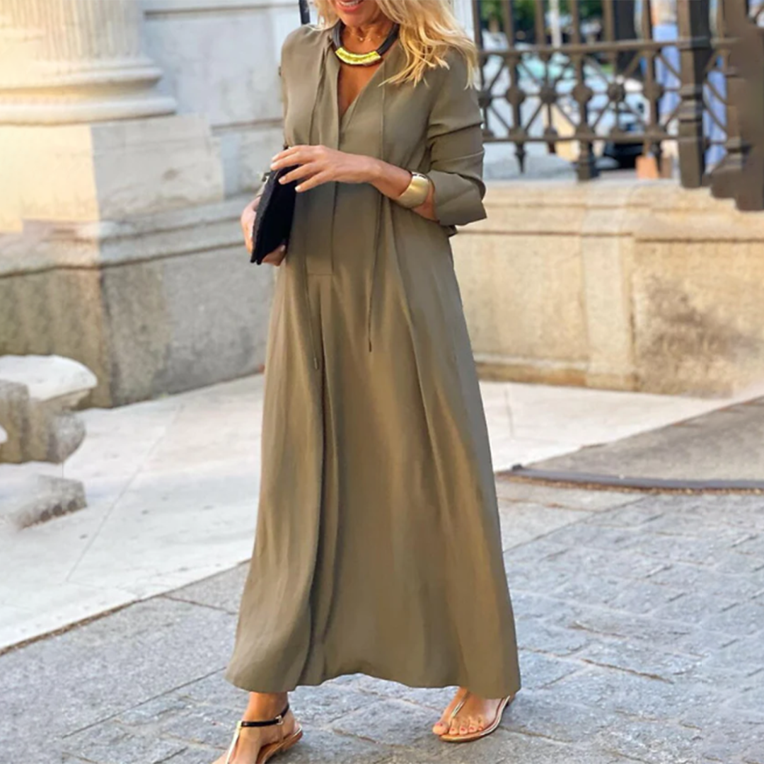 Modern damklänning i maxilängd med långa ärmar, V-ringning och sidofickor för en chic look.