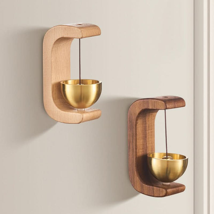 Vacker dörrklocka i trä och polerad mässing, en elegant detalj för heminredningen.