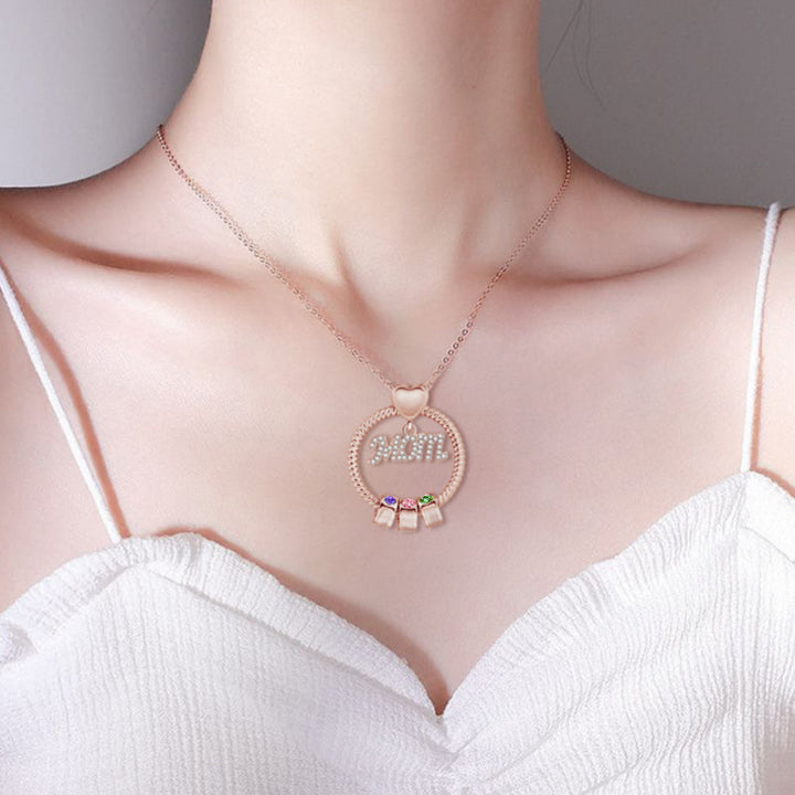 "Elegant mammas halsband med födelsesten i gyllene färg, intrikat hjärtdesign och tvinnad repdetalj för kvinnor."