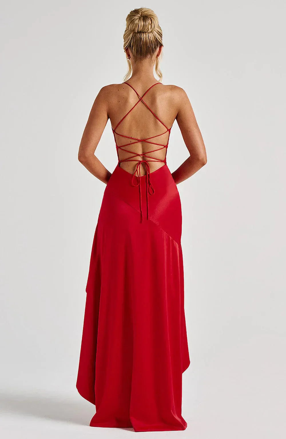 Närbild av den unika asymmetriska fållen på en elegant maxiklänning med smala spaghettiband.
