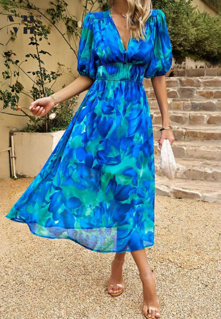 Modern kvinnlig midiklänning med färgstarkt abstrakt tryck, perfekt för en elegant sommarlook.
