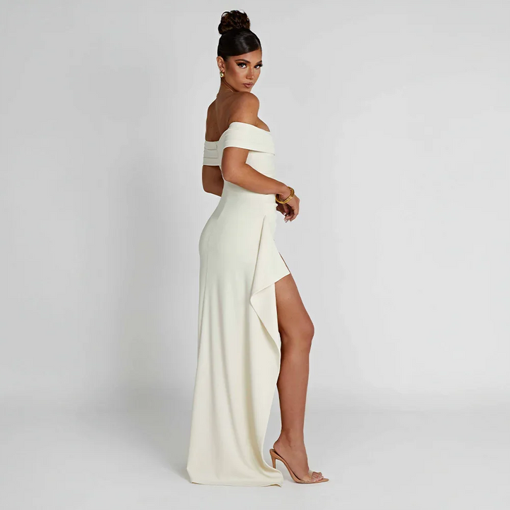 Modell bär elegant off shoulder maxiklänning i rött med slits, idealisk för kvällsfest.
