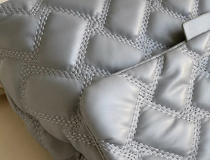 Detaljbild av en quiltad axelremsväska, elegant textur och högkvalitativ design för damer.
