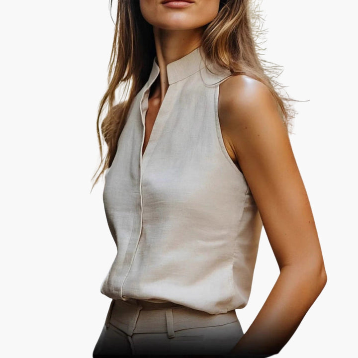 Stilren damtopp med unik delad krage, ärmlös design för en elegant look i både vardag och arbete.