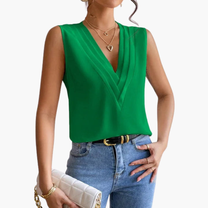 Kvinnlig ärmlös V-halsblus i somrig design med veckad front, stylad för en elegant och casual look.