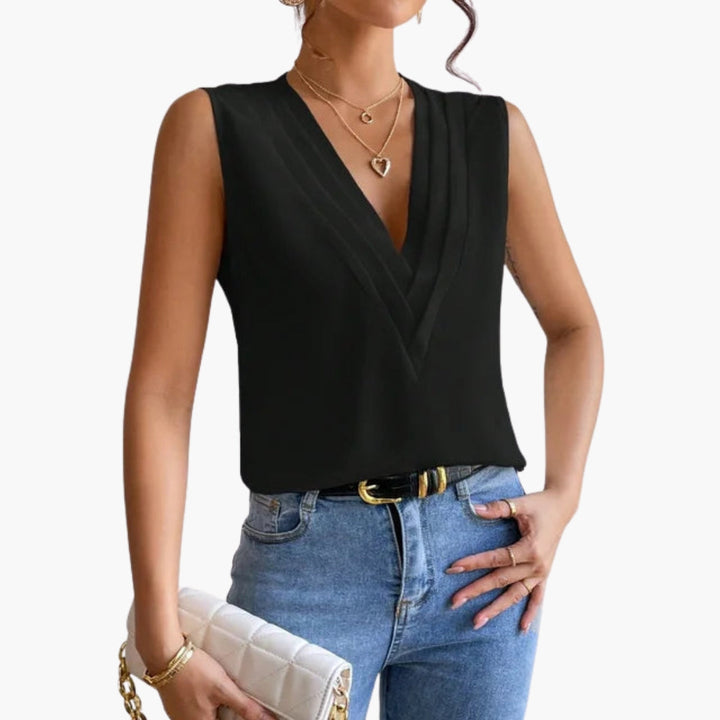 Modern ärmlös damtopp med v-ringning och veckad framdel, passar perfekt för en chic sommarstil.