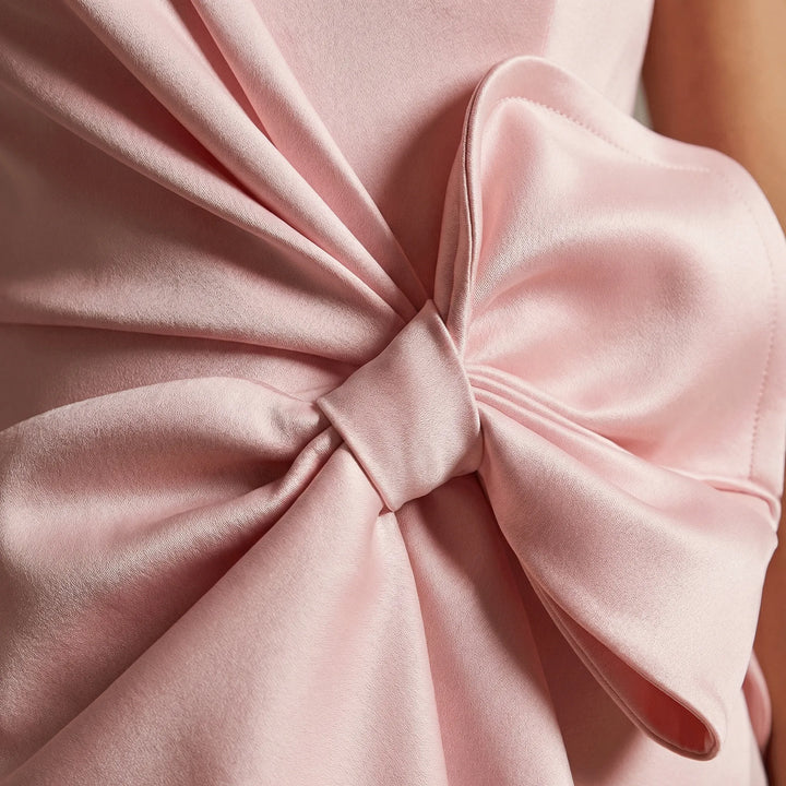 Formell ärmlös damklänning knälång med elegant rosett, idealisk för bröllopsgäst eller cocktailparty.