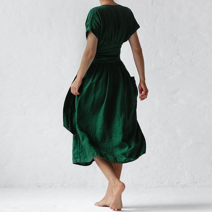 "Elegant rosa damklänning med hög midja, V-ringning, korta ärmar och fickor, perfekt för stilfulla tillfällen."