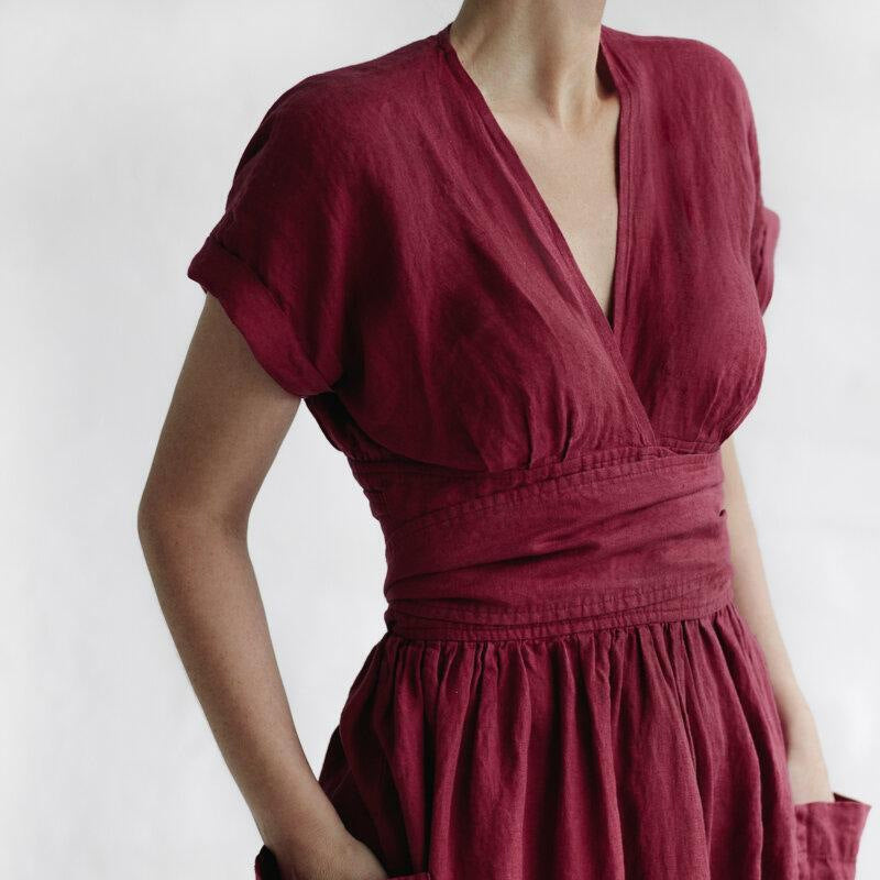 "Elegant rosa damklänning med hög midja, V-ringning, korta ärmar och fickor, perfekt för stilfulla tillfällen."