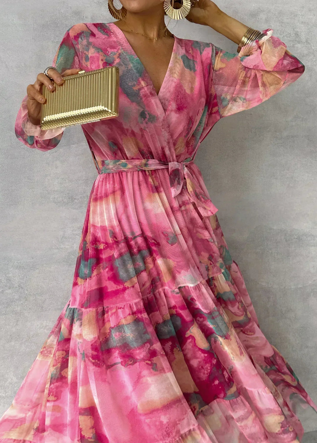 Vacker rosa maxiklänning för damer med elegant omlottdesign och långa ärmar. Idealisk festklänning.