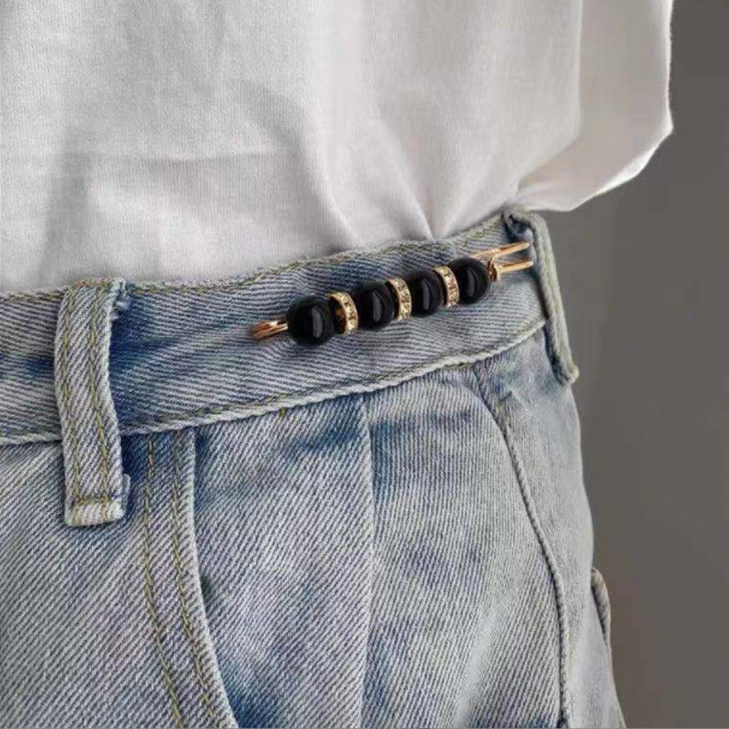 "Elegant säkerhetsnålsbrosch med vita pärlor och strass, perfekt för damkläder, i svart och vitt för stil och matchning."