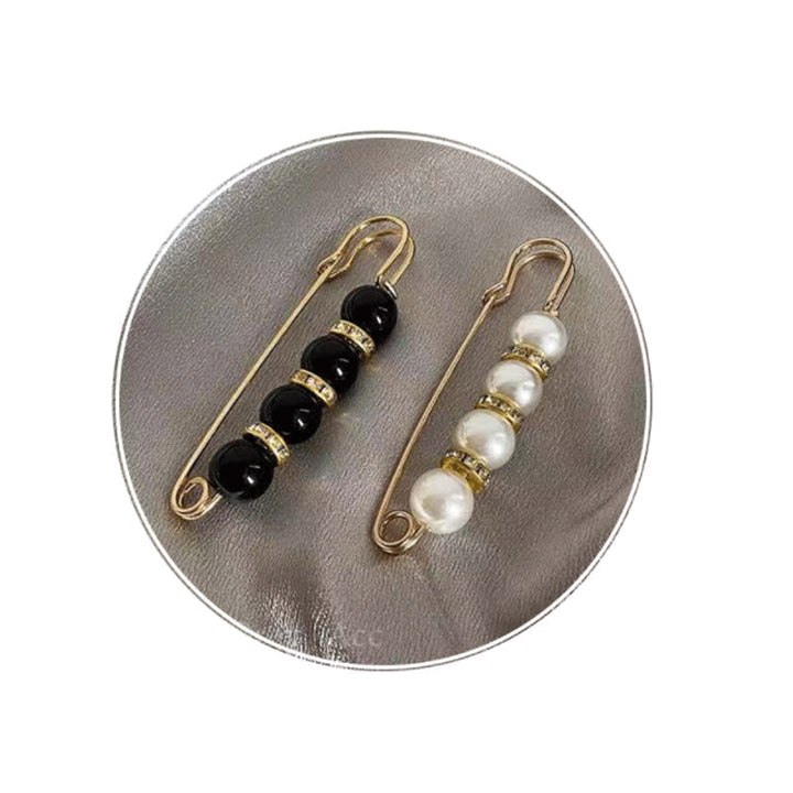 "Elegant säkerhetsnålsbrosch med vita pärlor och strass, perfekt för damkläder, i svart och vitt för stil och matchning."