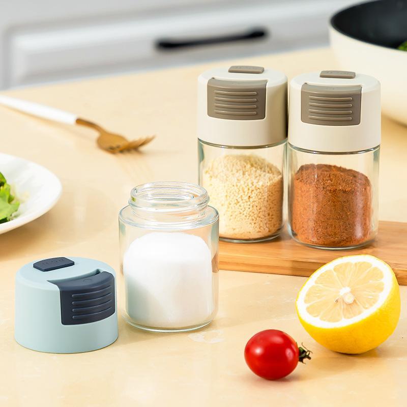 "Elegant saltkar i glas med mätfunktion, böjd form och modernt lock, perfekt för kryddförvaring i köket."
