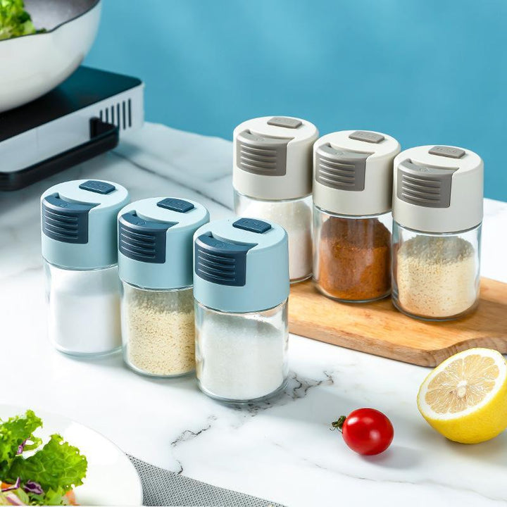 "Elegant saltkar i glas med mätfunktion, böjd form och modernt lock, perfekt för kryddförvaring i köket."