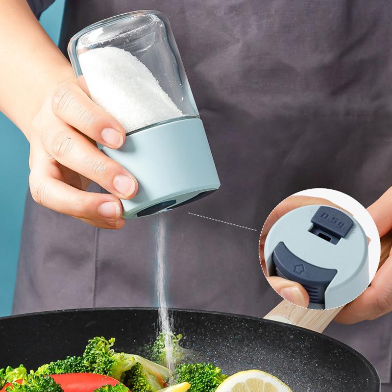 "Elegant saltkar i glas med mätfunktion, böjd form och modernt lock, perfekt för kryddförvaring i köket."