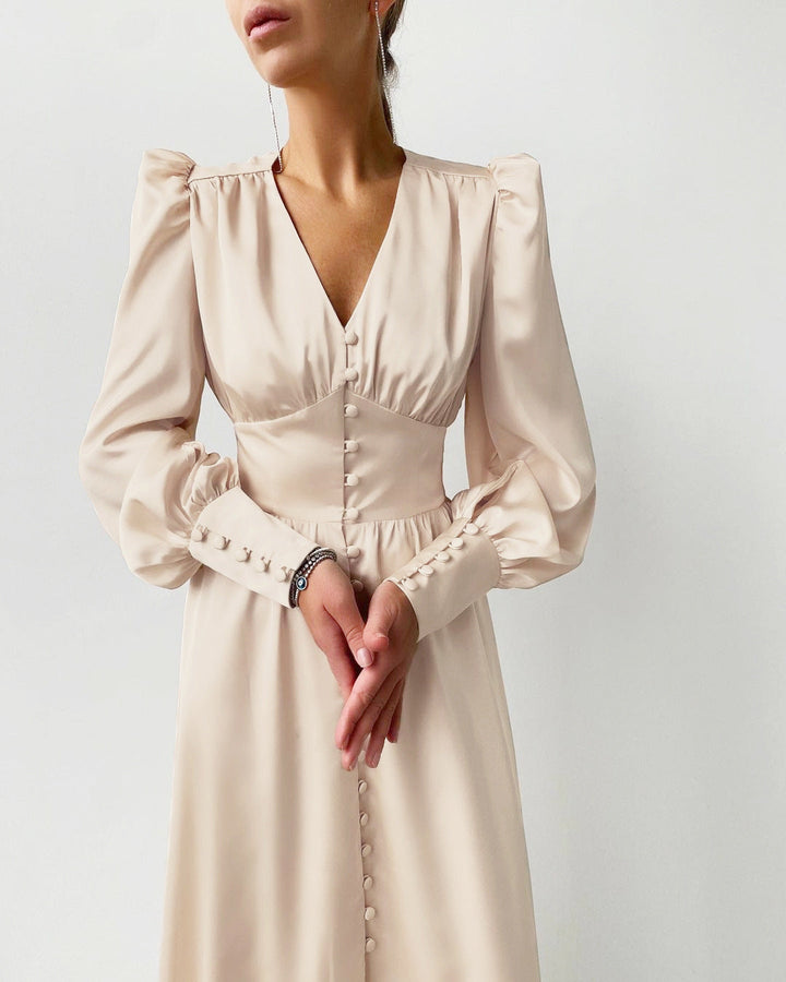 Ryggdetalj på en elegant satinklänning, visar den smickrande silhuetten i satin.