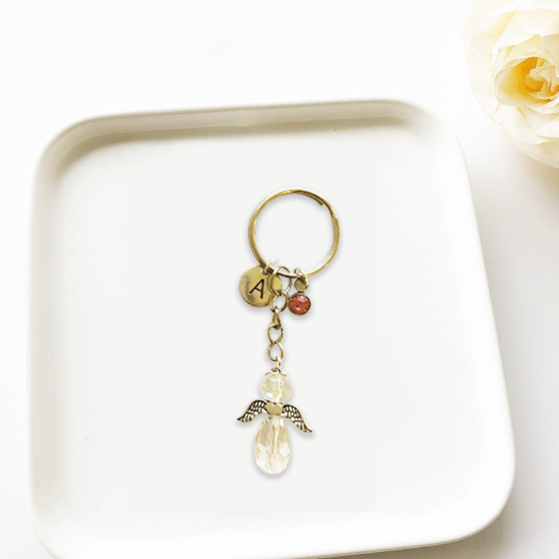"Elegant skyddsängel nyckelring i metall med glaspärlor, symboliserar vänskap. Perfekt för kvinnor som accessoar."