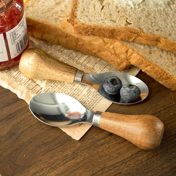 "Elegant stående smörkniv set i rostfritt stål och akaciaträ för köksanvändning, visad i nära bild."