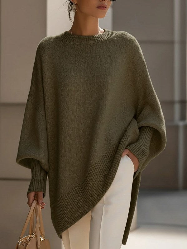 Kvinna bär en elegant, oversize stickad damponcho, som visar dess mångsidighet och bekväma passform.