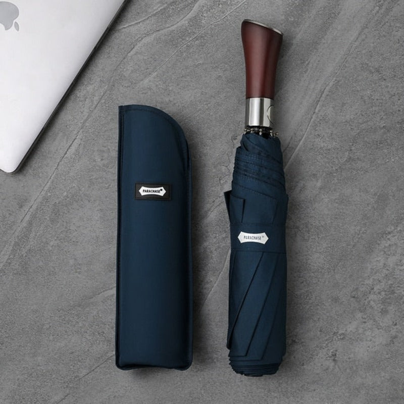 Närbild på ett elegant automatiskt paraply med polerat trähandtag. En stilren accessoar mot regn.
