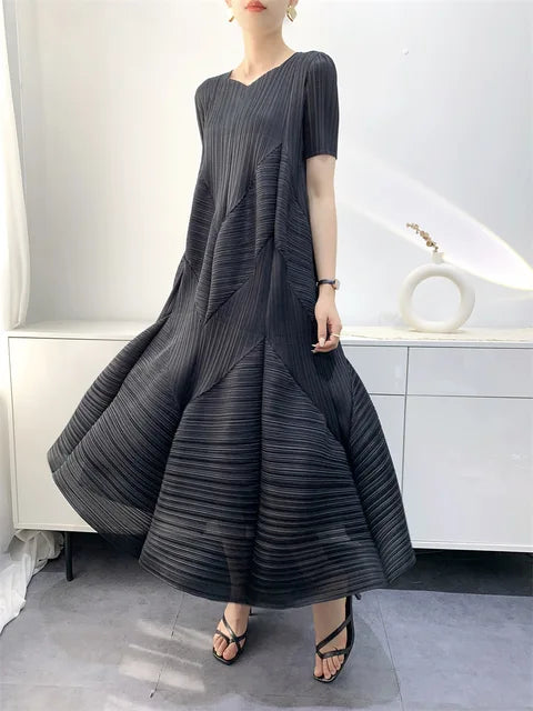 Elegant beige klänning i bubbeldesign, poserande för en festlig sommarkväll.