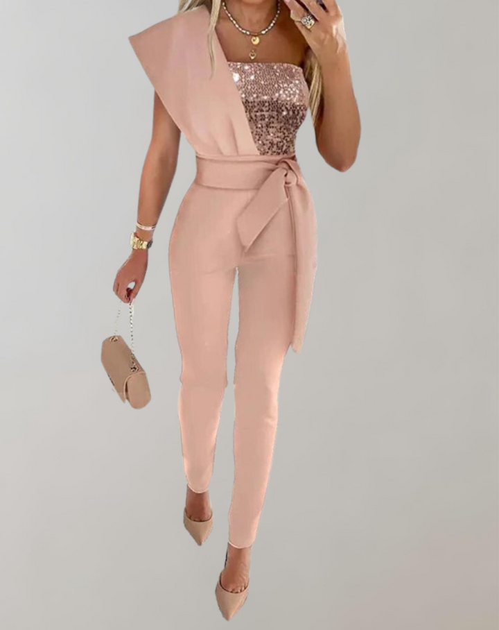Glittrig byxdress med rosettband i midjan, framhäver silhuetten för en smickrande look.