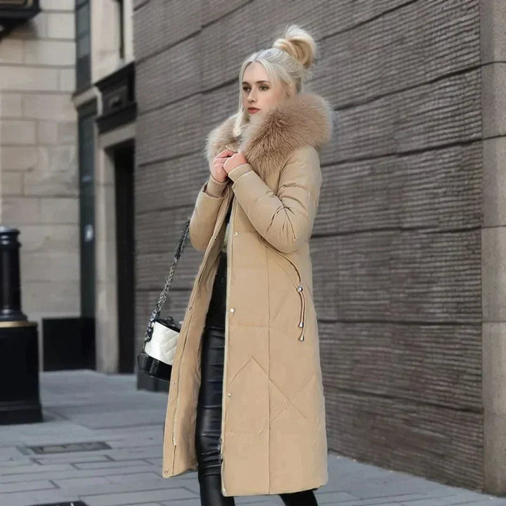Baksida av en kvinnors vinterkappa med elegant fuskpäls krage, betonar den slimmade och moderna designen. Vardagsstil.