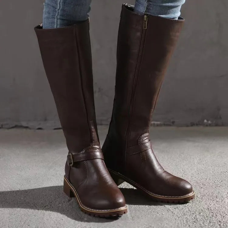 Närbild av spänne på en elegant kvinnors läderstövel, framhäver detaljer och hantverk, perfekt för chic stil.