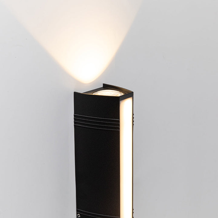 Elegant svart LED-lampa med upp/ner-ljus, perfekt för utomhusbruk.