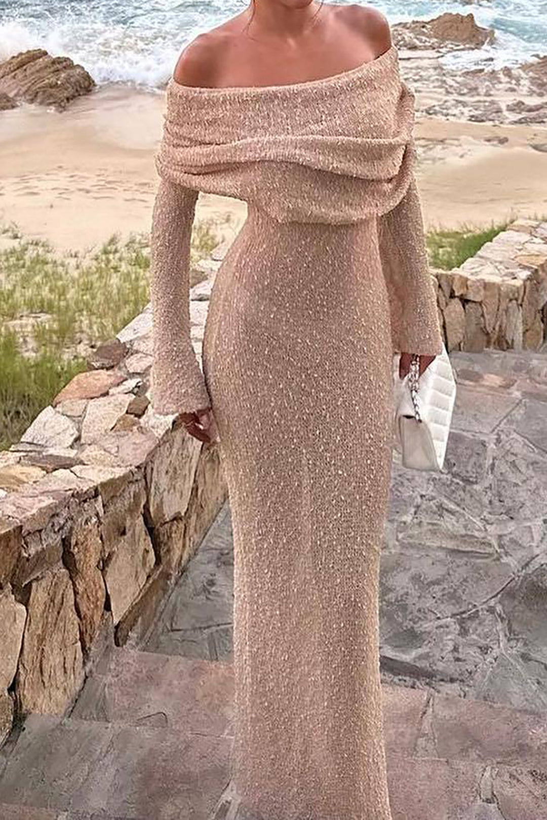 Modell som bär en off shoulder maxiklänning, betonar dess smickrande passform och stil.
