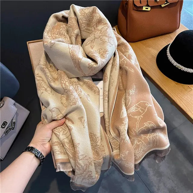 Produktbild: Vikta pashminasjalar i svart, brunt och grått, redo att användas som varm accessoar.