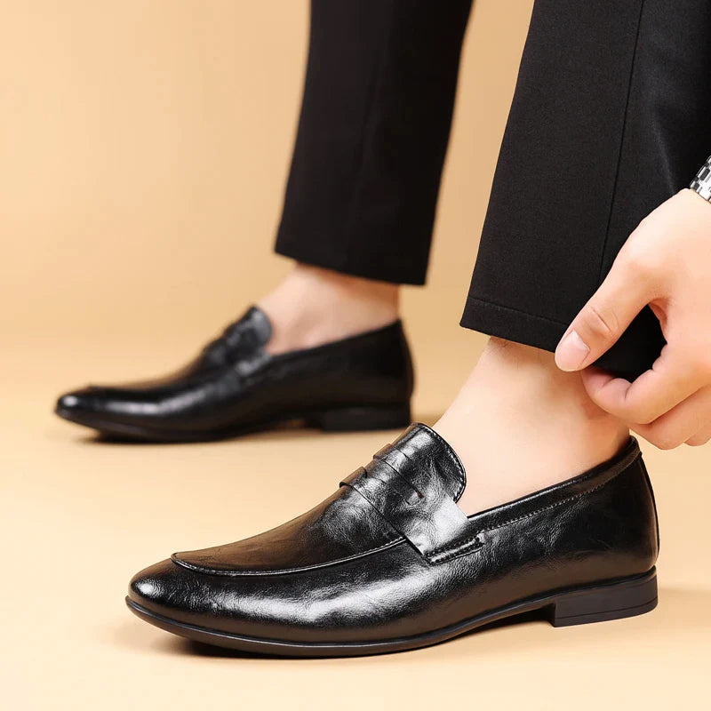 Herrloafers i brunt läder sedda från sidan, med fokus på den eleganta siluetten