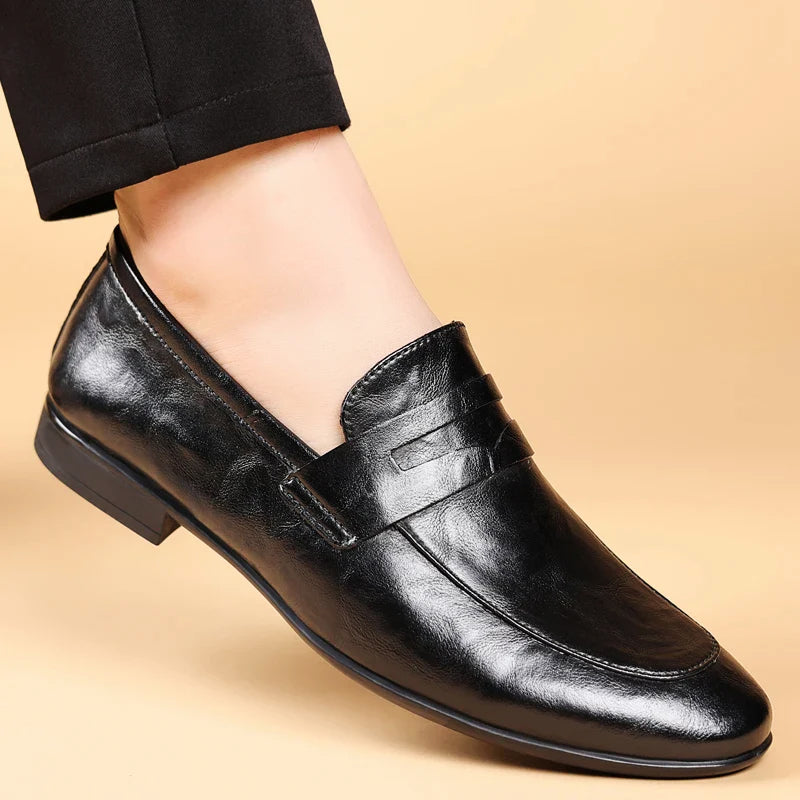 Ett par svarta läderloafers för män, redo att bäras, symboliserar mode och komfort