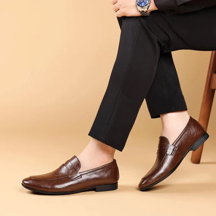 Två par herrloafers i läder, en svart och en brun, som visar färgval för mode