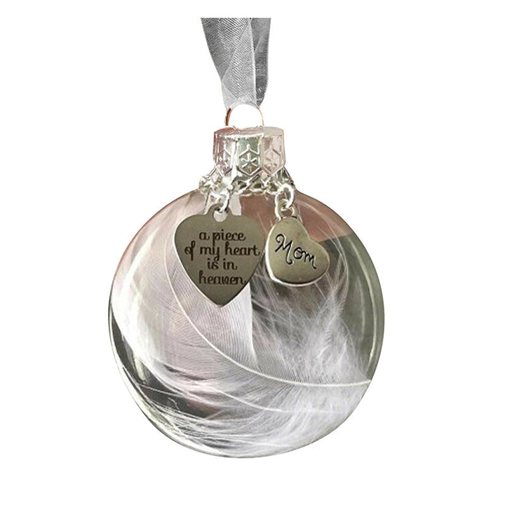 "Elegant transparent julkula med vit fjäder och gravering, perfekt för juldekoration eller som en omtänksam gåva."