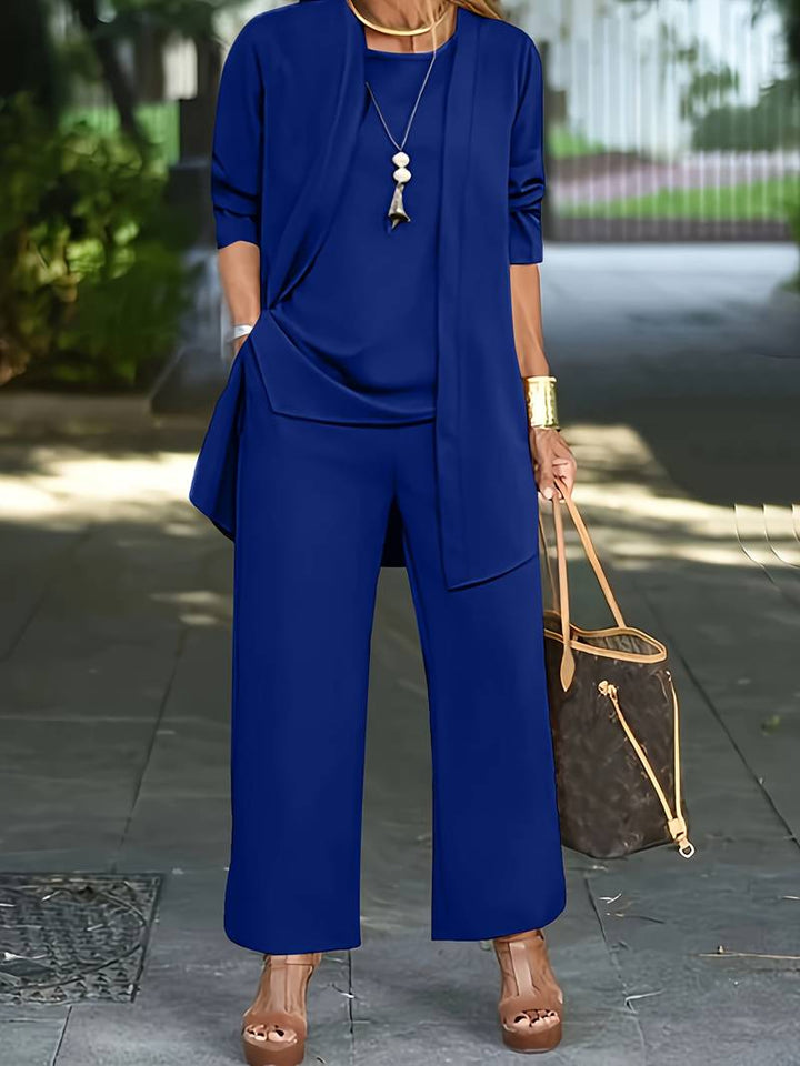 Dammodell visar tredelad byxdress i klassisk stil. Elegant festkläder eller vardagsmode för kvinnor.