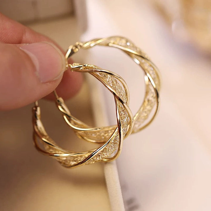 "Elegant twist örhängen för kvinnor i guld och silver, geometrisk design, perfekt accessoar för alla tillfällen."