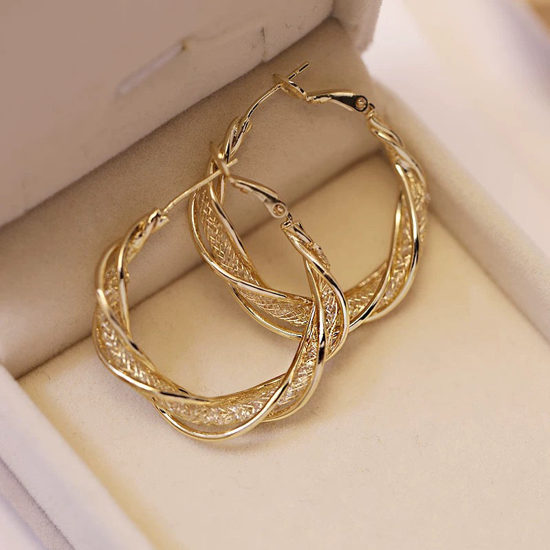 "Elegant twist örhängen för kvinnor i guld och silver, geometrisk design, perfekt accessoar för alla tillfällen."