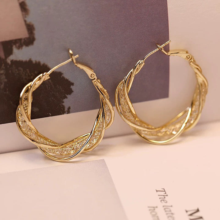 "Elegant twist örhängen för kvinnor i guld och silver, geometrisk design, perfekt accessoar för alla tillfällen."