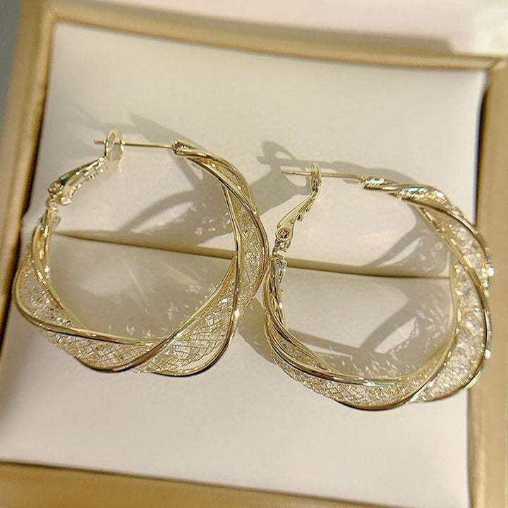 "Elegant twist örhängen för kvinnor i guld och silver, geometrisk design, perfekt accessoar för alla tillfällen."