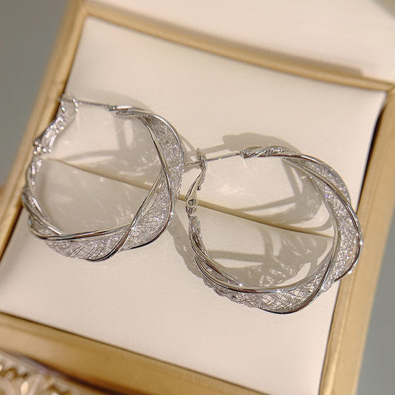 "Elegant twist örhängen för kvinnor i guld och silver, geometrisk design, perfekt accessoar för alla tillfällen."
