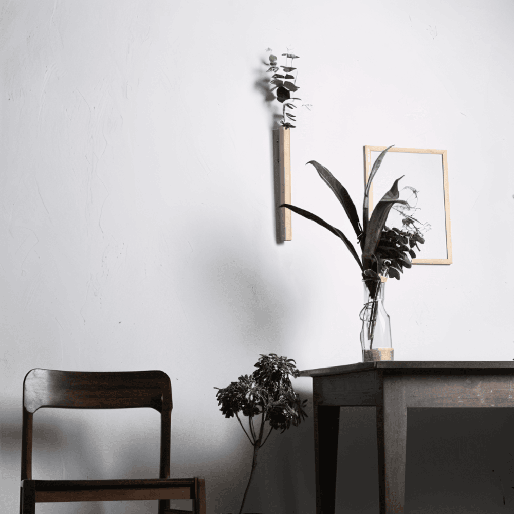 Modern väggmonterad blomvas i massivt bokträ och mörk valnöt. Skandinavisk design.