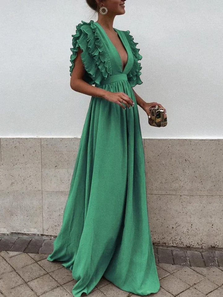 Elegant v-ringad damklänning med volangkanter, perfekt för en stilren look. Passar sommar och fest.