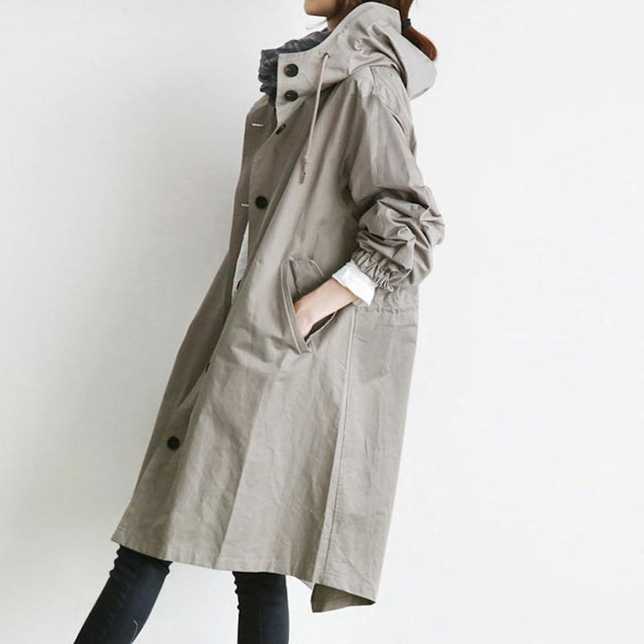 "Elegant vattentät trenchcoat för kvinnor med dragsko, elastiska manschetter och avslappnad passform i beige."